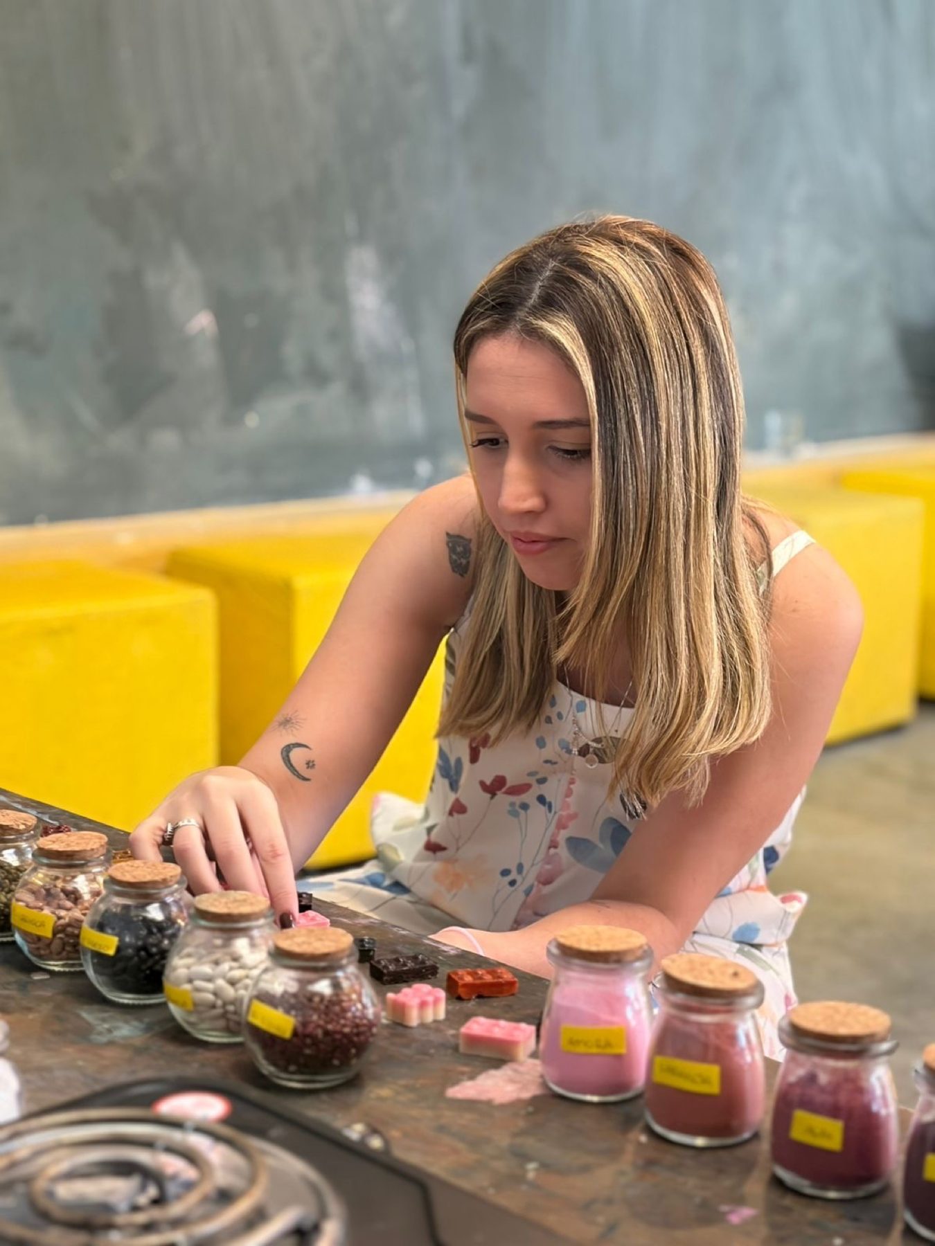 Bruna Aranda organizando potes e materiais sensoriais em uma mesa da Buba.